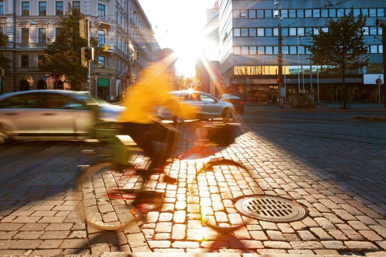 En cyklist mot bakljus i en stad